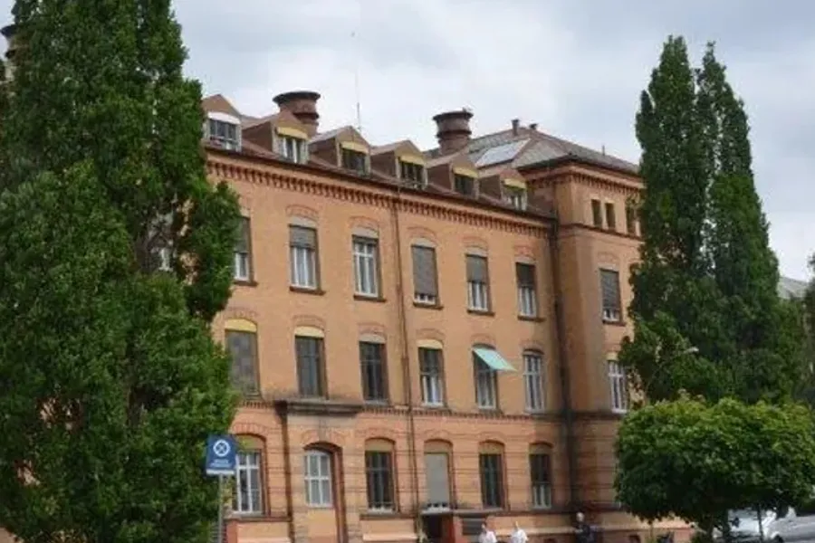 En stor bygning med trær foran seg