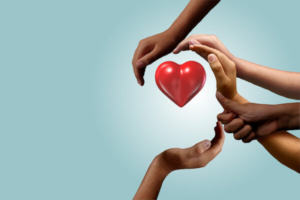 Hender som holder et rødt hjerte