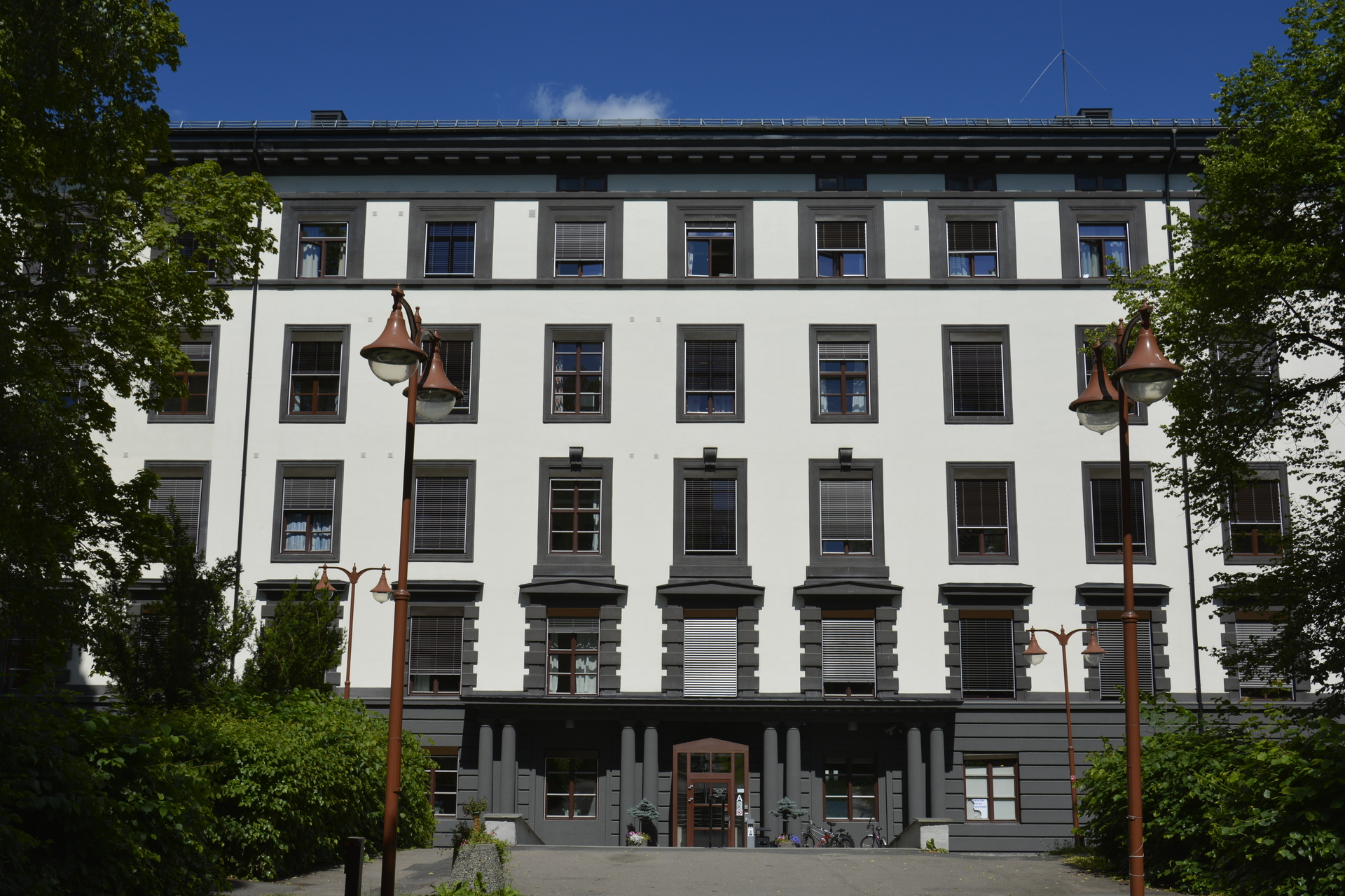 En hvit bygning med trær foran