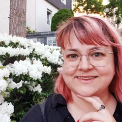 En kvinne med rødt hår og briller