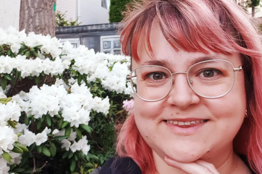 En kvinne med rødt hår og briller