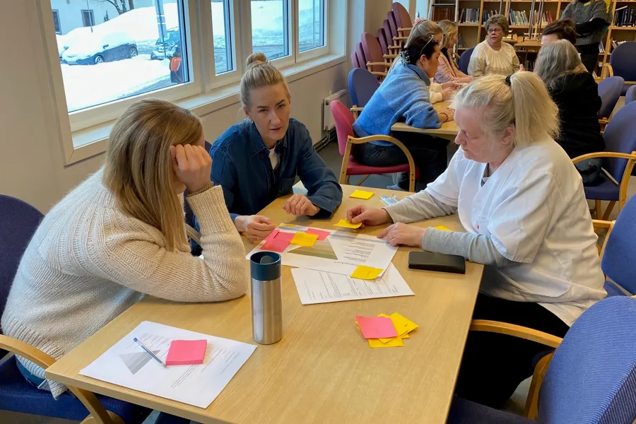 En gruppe mennesker som sitter ved et bord