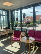 Et rom med bord, stoler og et vindu med utsikt utover