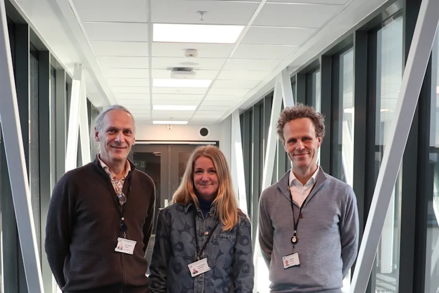 Noen få mennesker som står i en gang