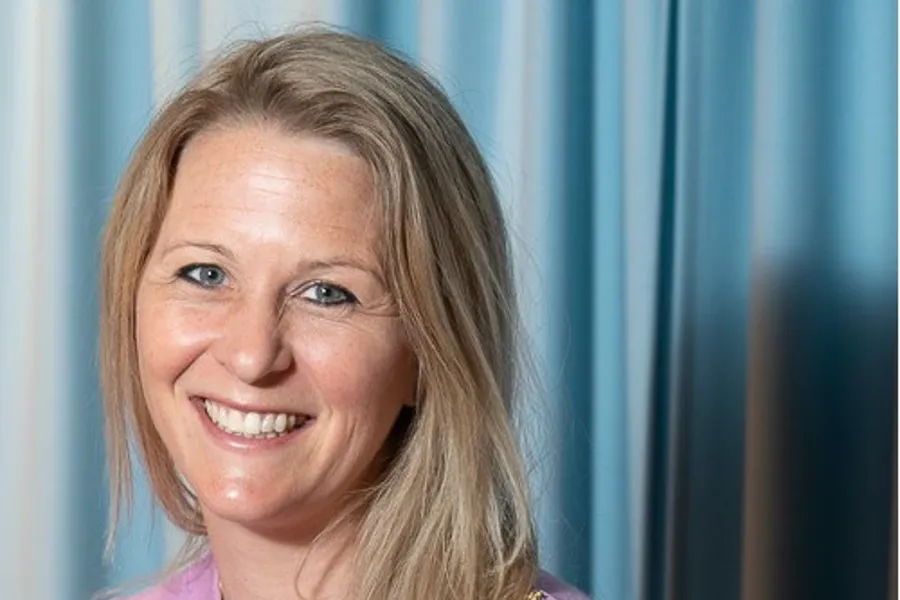 En kvinne som smiler til kameraet