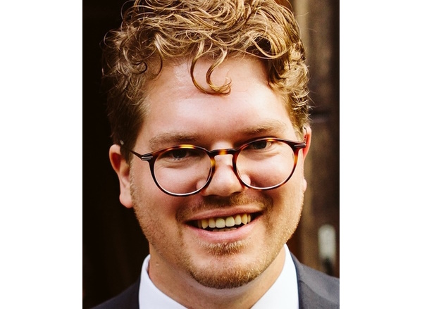 En mann med briller som smiler