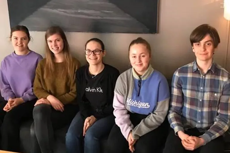 En gruppe mennesker som sitter i en sofa
