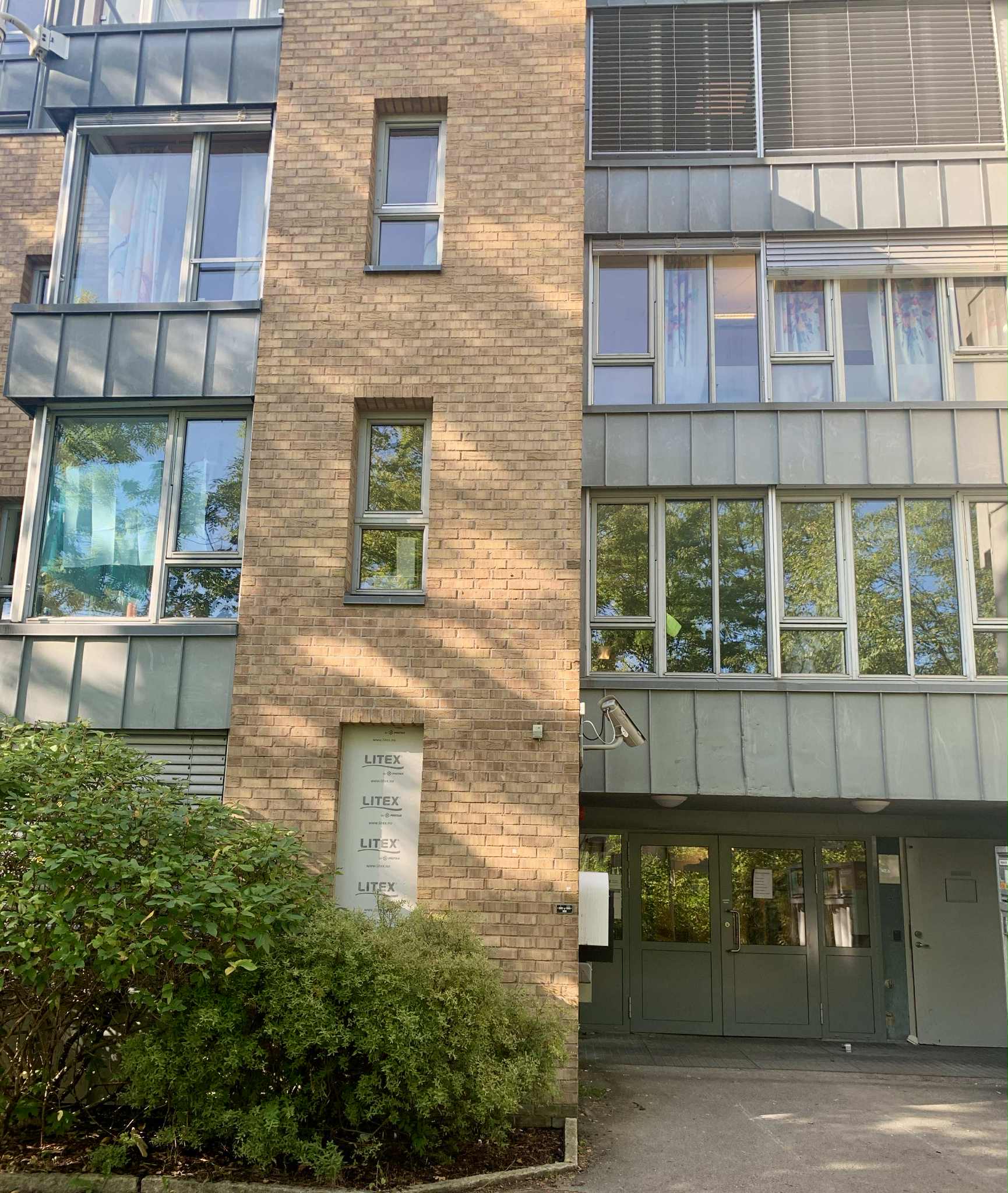 En bygning med vinduer og busker foran