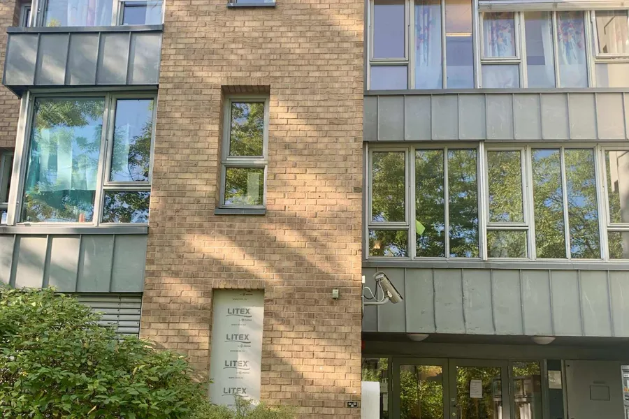 En bygning med vinduer og busker foran