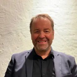 En mann som smiler til kameraet