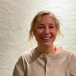 En kvinne som smiler til kameraet