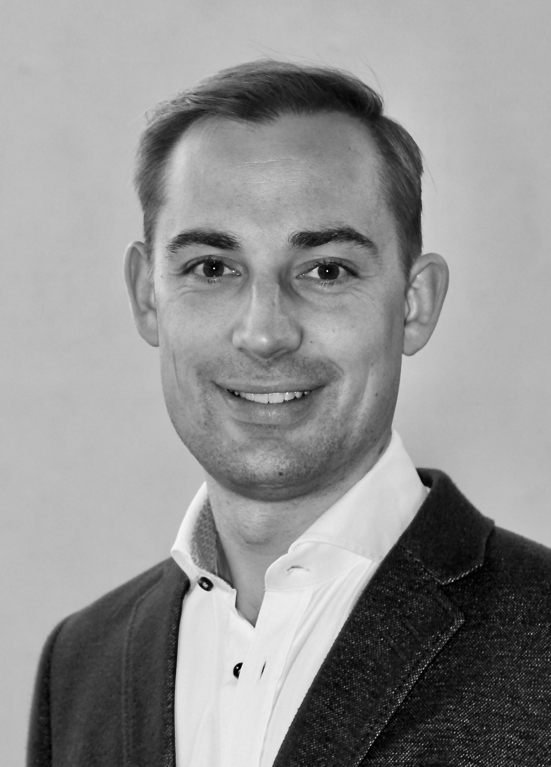 En mann som smiler til kameraet