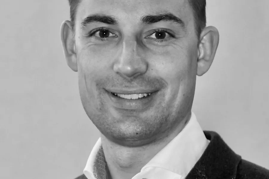 En mann som smiler til kameraet