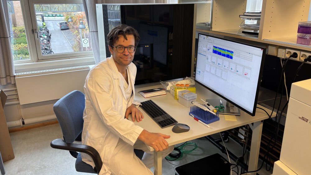 En person som sitter ved et skrivebord med en datamaskin