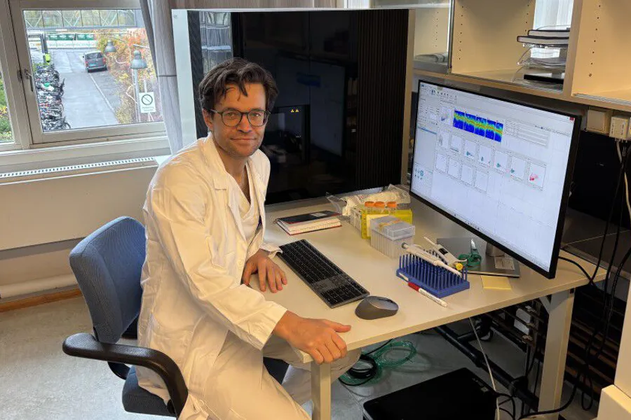 En person som sitter ved et skrivebord med en datamaskin