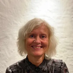 En kvinne som smiler til kameraet